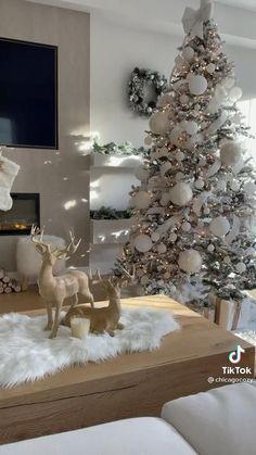 a living room decorated for christmas with white and silver decorations on the fireplace mantel