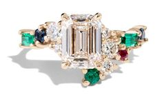 an emerald and diamond ring with multi - colored stones