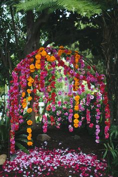 an outdoor ceremony with flowers on the ground and trees in the backgrouf