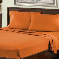 an orange sheet set on a bed in a bedroom