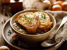 two pieces of bread in a bowl on a plate with garlic and mushrooms around it