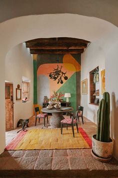 an archway leads to a dining room with cactus and succulents on the table