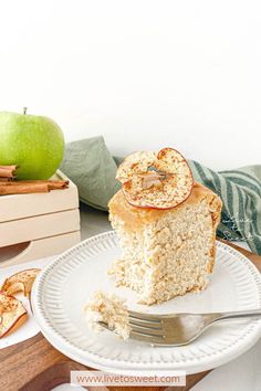 a piece of apple cake on a plate with a fork and an apple in the background