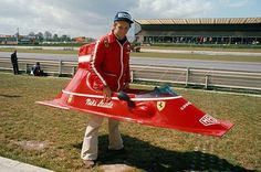 a man in red jacket holding a small airplane