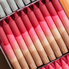 several different shades of pink and orange in a box