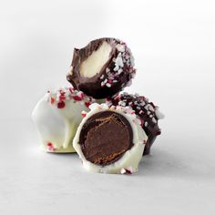 three pieces of chocolate covered candy with white and red sprinkles on top