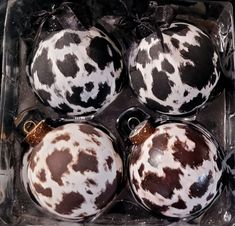 four black and white ornaments in a box