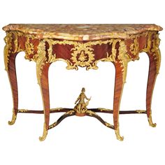 an ornately decorated console table with gold leaf decoration on the top and bottom edge