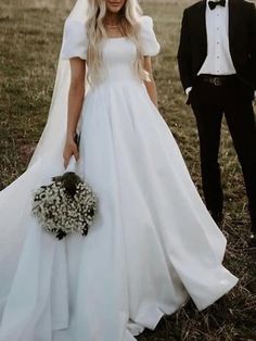 a woman in a wedding dress standing next to a man wearing a tuxedo