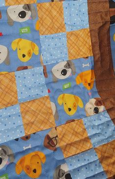 a blue and yellow quilt with dogs on it