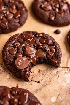 a chocolate cookie is cut in half and sitting on a piece of parchment paper next to other cookies