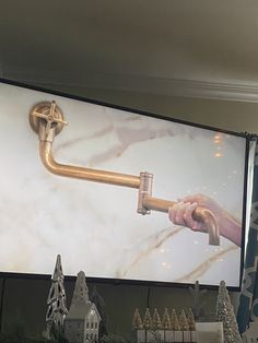 a person is holding a pipe in front of a large screen