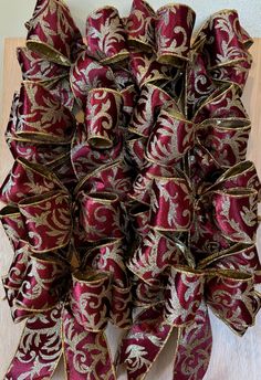 a large red and gold bow on top of a wooden table