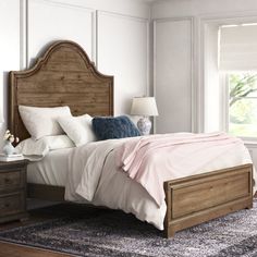 a bedroom with white walls and wooden furniture