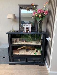 a black cabinet with flowers and a house in it