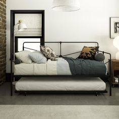 a bed sitting next to a brick wall in a room with white walls and flooring