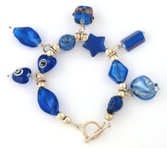 "We are pleased to present, for your consideration, this beautiful vintage Murano Art Glass charm style bracelet. Made of varied cobalt blue Art Glass beads and dangles, separated by silver tone beads. Measures: 7 1/4\" x 1 1/2\" (18.4 x 3.8 cm) In very good vintage condition. Look at photos for details. Will look superb when worn or in collection !" Blue Beaded Bracelets With Dangling Beads For Gift, Blue Dangle Bracelets For Gift, Adjustable Blue Bracelets With Dangling Beads, Elegant Blue Nickel Free Charm Bracelet, Blue Charm Bracelets For Jewelry Making, Handmade Blue Costume Jewelry Bracelets, Blue Vintage Nickel Free Bracelets, Vintage Blue Beaded Bracelets With Round Beads, Handmade Vintage Blue Beaded Bracelets