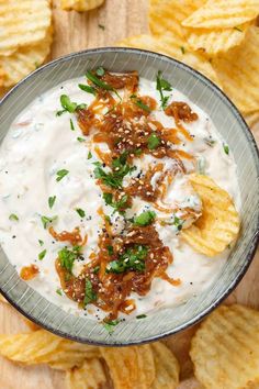 a bowl filled with ranch dip surrounded by chips