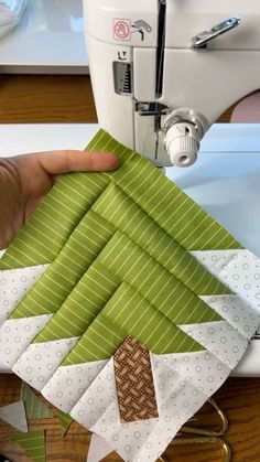 someone is using a sewing machine to sew a christmas tree