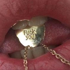 a close up view of a person's mouth with a gold ring on it