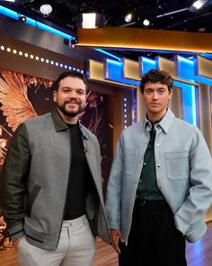 two men standing next to each other on a tv set