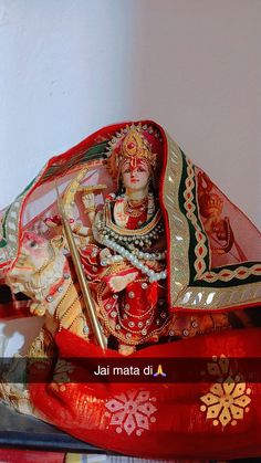 a statue of the hindu god ganesh on top of a red cloth covered box