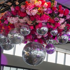 disco balls hanging from the ceiling in front of flowers