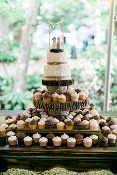 a wedding cake and cupcakes on a table