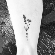 a small flower tattoo on the ankle with words written in cursive font below it