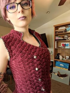 a woman with pink hair wearing glasses and a red dress is standing in front of a bookshelf