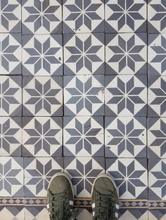 a pair of shoes sitting on top of a tiled floor