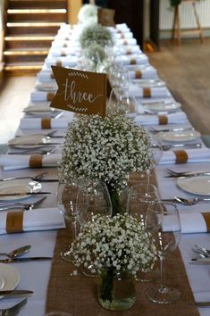 the table is set with place cards and wine glasses for guests to sit down at