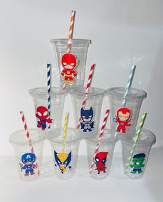 the cups have different designs on them and are lined up with paper straws,