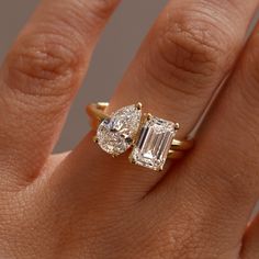 a woman's hand with two engagement rings on it