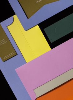 an assortment of different colored envelopes and business cards