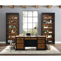 an office desk with open bookcases in front of a large window