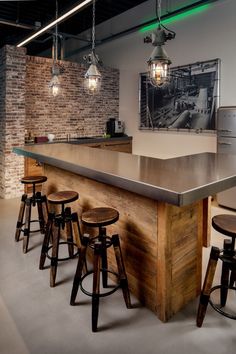 an industrial style bar with stools and lights