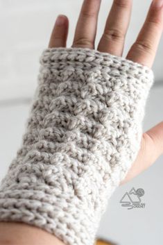 a hand is shown with a knitted arm warmer on it's left side