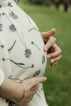 a pregnant woman holding her belly in the park