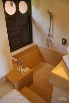 a bathroom with a sink, mirror and shower head in the corner next to an open window