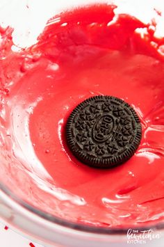 an oreo cookie sitting on top of red liquid