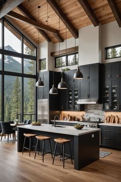 a large kitchen with black cabinets and wooden floors, along with an island in the middle