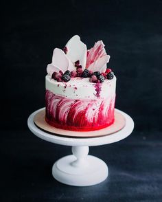 a birthday cake with berries on top and the words happy birthday written in white letters