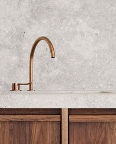 a faucet that is sitting on top of a sink in a room with wooden cabinets