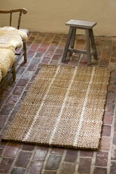 a bench sitting next to a rug on top of a floor