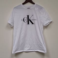 Nwt Calvin Klein Brilliant White Logo Tee Mens Medium Calvin Klein Casual Tops For Streetwear, Casual Calvin Klein Tops For Streetwear, Classic Calvin Klein Crew Neck Top, White Crew Neck Top By Calvin Klein, Calvin Klein Short Sleeve Streetwear Top, Calvin Klein Relaxed Fit Letter Print Top, Calvin Klein Basic Short Sleeve Tops, Calvin Klein Cotton Tops With Letter Print, Calvin Klein Casual Crew Neck Shirt