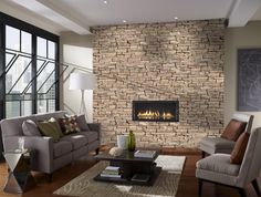 a living room filled with furniture and a fire place in the middle of a wall