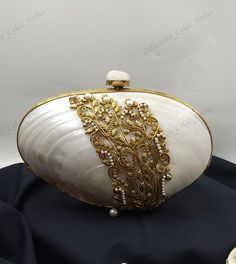 Handmade Sea Shell Minaudiere Purse Gold Filigree and Pearl Detail Shoulder bag, Mother of Pearl craftsmanship  Add a touch of elegance and sophistication to your evening ensemble with this exquisite handcrafted clutch bag. This stunning accessory features a natural Mother of Pearl shell, beautifully complemented by intricate gold filigree detailing and delicate pearl accents. The combination of these elements creates a luxurious and unique design that is sure to turn heads. Why You'll Love It: Gold Filigree, Pearl Shell, Sea Shell, Evening Bags, Mother Of Pearl, Sea Shells, Clutch Bag, Unique Design, Shells