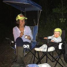 two people sitting in lawn chairs with hats on