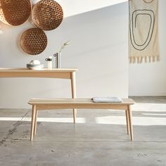 a wooden bench sitting in the middle of a room next to a table with a towel on it